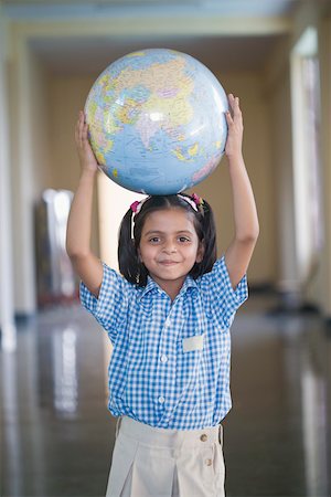 Portrait of a schoolgirl carrying a globe on her head Stock Photo - Premium Royalty-Free, Code: 630-01873816