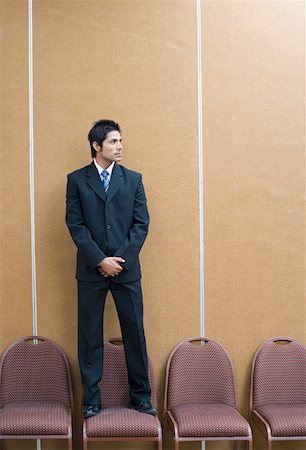 full room - Businessman standing on a chair Stock Photo - Premium Royalty-Free, Code: 630-01873889