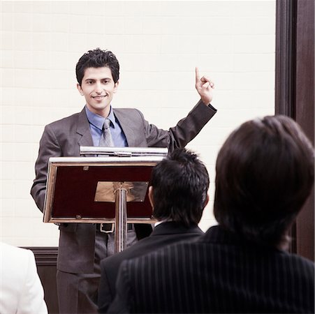 suit man standing backside - Businessman giving speech in a seminar Foto de stock - Sin royalties Premium, Código: 630-01873923