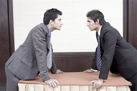 Side profile of two businessmen looking at each other Stock Photo - Premium Royalty-Free, Code: 630-01873982