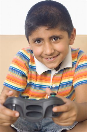 simsearch:630-02220721,k - Portrait of a boy playing video game and smiling Foto de stock - Sin royalties Premium, Código: 630-02219228