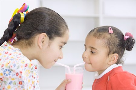 smoothie with two straws - Two girls drinking a glass of milk shake Stock Photo - Premium Royalty-Free, Code: 630-02219301