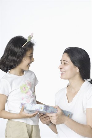 simsearch:630-02219353,k - Mid adult woman giving a gift to her daughter Stock Photo - Premium Royalty-Free, Code: 630-02219350