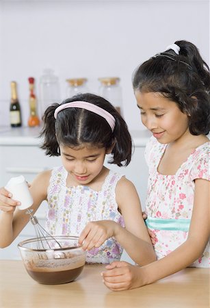 simsearch:630-02219554,k - Two sisters making chocolate shake in the kitchen Stock Photo - Premium Royalty-Free, Code: 630-02219352