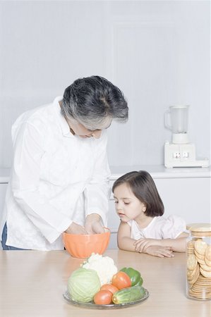 simsearch:630-02219554,k - Girl looking at her grandmother preparing food Stock Photo - Premium Royalty-Free, Code: 630-02219363
