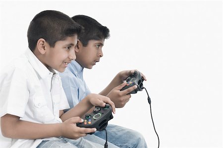 simsearch:630-02220721,k - Side profile of two boys playing video game Foto de stock - Sin royalties Premium, Código: 630-02219404