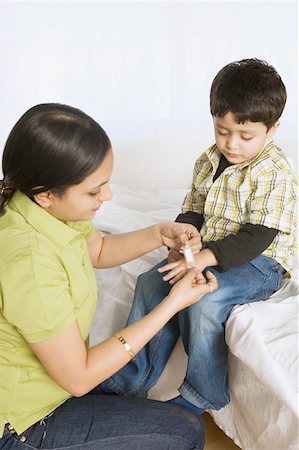 simsearch:695-03389917,k - Close-up of a young woman applying a bandage to her son's hand Foto de stock - Royalty Free Premium, Número: 630-02219430