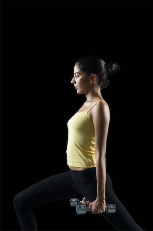 simsearch:630-02219691,k - Side profile of a young woman exercising with dumbbells Foto de stock - Sin royalties Premium, Código: 630-02219501