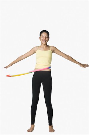 simsearch:630-02219883,k - Portrait of a young woman spinning plastic hoop around her waist Foto de stock - Sin royalties Premium, Código: 630-02219502