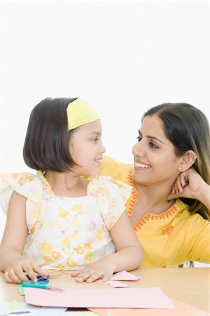 scissors papers - Young woman and her daughter looking at each other and smiling Stock Photo - Premium Royalty-Free, Code: 630-02219519