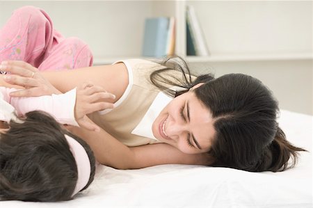 simsearch:630-02221095,k - Close-up of a mid adult woman playing with her daughter on the bed Foto de stock - Sin royalties Premium, Código: 630-02219549