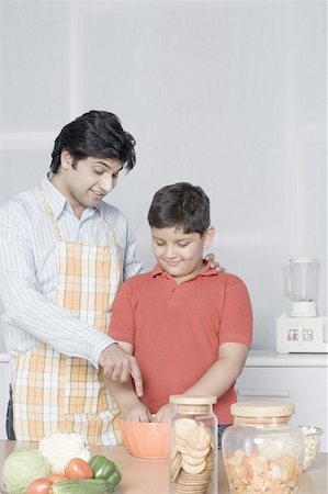 simsearch:630-02219554,k - Young man helping his son in preparing food Stock Photo - Premium Royalty-Free, Code: 630-02219554