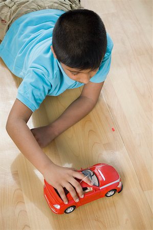 simsearch:630-02220721,k - High angle view of a boy playing with a toy car Foto de stock - Sin royalties Premium, Código: 630-02219600