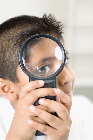 Portrait of a boy looking through a magnifying glass Stock Photo - Premium Royalty-Free, Code: 630-02219601