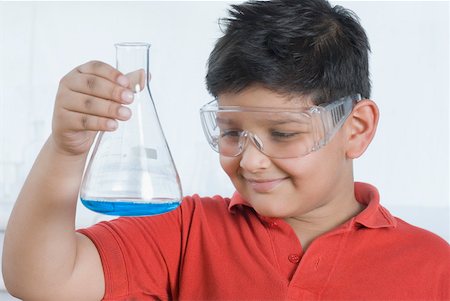 Close-up of a boy holding a conical flask and smiling Stock Photo - Premium Royalty-Free, Code: 630-02219664