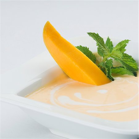 simsearch:630-02220065,k - Bowl of cream with mango slices and mint leaves Foto de stock - Sin royalties Premium, Código: 630-02219676