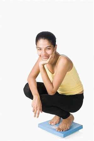 simsearch:630-02219691,k - Portrait of a young woman on a weighing scale Foto de stock - Sin royalties Premium, Código: 630-02219693