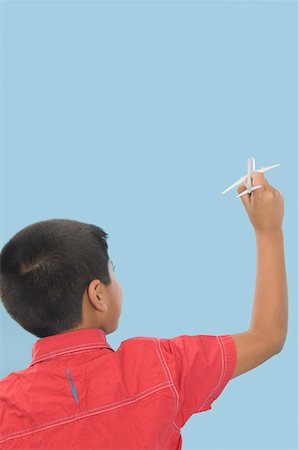 Rear view of a boy playing with a model airplane Stock Photo - Premium Royalty-Free, Code: 630-02219805