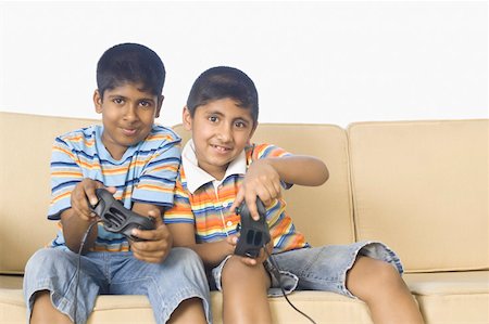 sofa two boys video game - Portrait of two boys playing video game and smiling Stock Photo - Premium Royalty-Free, Code: 630-02219800