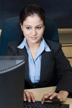 simsearch:630-02220797,k - Femme d'affaires travaillant sur un ordinateur dans un bureau Photographie de stock - Premium Libres de Droits, Code: 630-02219830