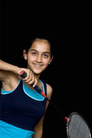 Teenage girl holding a badminton racket and smiling Stock Photo - Premium Royalty-Free, Code: 630-02219863