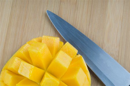 Close-up of mango slices with a knife on a cutting board Foto de stock - Sin royalties Premium, Código: 630-02219870