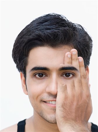 disappear - Portrait of a young man covering his one eye with his hand Stock Photo - Premium Royalty-Free, Code: 630-02219895