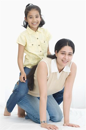 simsearch:630-02219353,k - Portrait of a girl sitting on her mother's back and smiling Stock Photo - Premium Royalty-Free, Code: 630-02219937