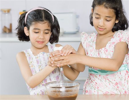 simsearch:630-02219554,k - Close-up of two sisters preparing food in the kitchen Foto de stock - Sin royalties Premium, Código: 630-02219941