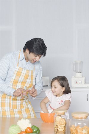 simsearch:630-02219554,k - Young man looking at his daughter preparing food Stock Photo - Premium Royalty-Free, Code: 630-02219952