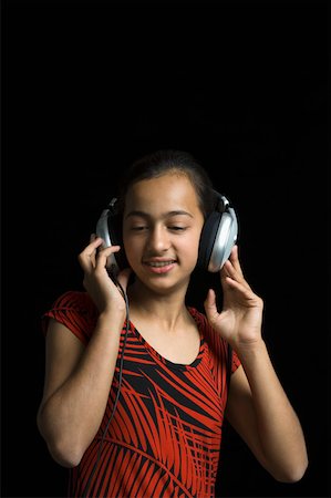 Close-up of a girl listening to music with headphones Stock Photo - Premium Royalty-Free, Code: 630-02220047