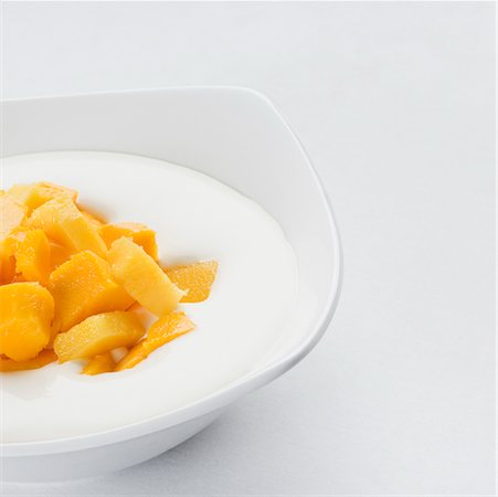 Close-up of a bowl with mango slices and cream Stock Photo - Premium Royalty-Free, Code: 630-02220065