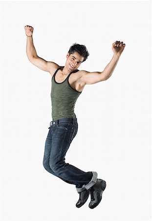 simsearch:630-02219895,k - Portrait of a young man jumping with his arms raised and smiling Stock Photo - Premium Royalty-Free, Code: 630-02220079