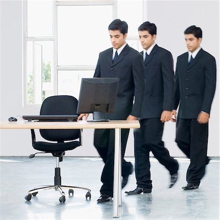 simsearch:630-02219583,k - Businessman walking towards his desk Stock Photo - Premium Royalty-Free, Code: 630-02220084