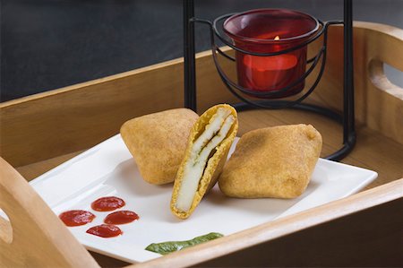 fried bread - High angle view of three bread pakoras with sauce in a tray Stock Photo - Premium Royalty-Free, Code: 630-02220096