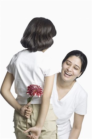 Rear view of a girl hiding a flower from her mother Stock Photo - Premium Royalty-Free, Code: 630-02220134