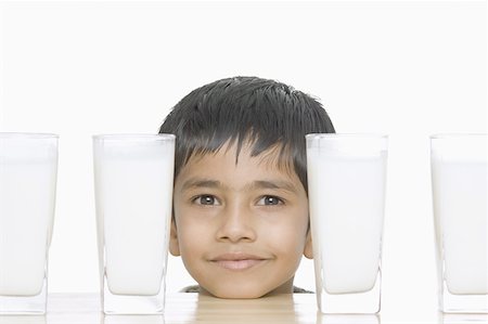simsearch:630-02219570,k - Portrait d'un garçon avec des verres de lait sur une table Photographie de stock - Premium Libres de Droits, Code: 630-02220163