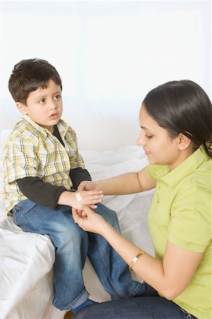 Gros plan d'une jeune femme, appliquer un bandage à la main de son fils Photographie de stock - Premium Libres de Droits, Code: 630-02220222