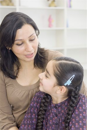 Close-up of a mid adult woman with her daughter smiling Stock Photo - Premium Royalty-Free, Code: 630-02220268