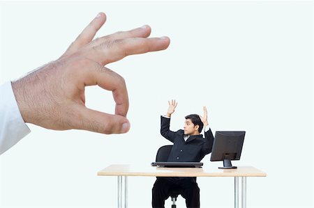 dominating office - Person's hand flicking a businessman sitting with his arms raised Stock Photo - Premium Royalty-Free, Code: 630-02220289