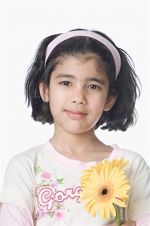 smirk girl - Portrait of a girl holding flowers and smirking Stock Photo - Premium Royalty-Free, Code: 630-02220333