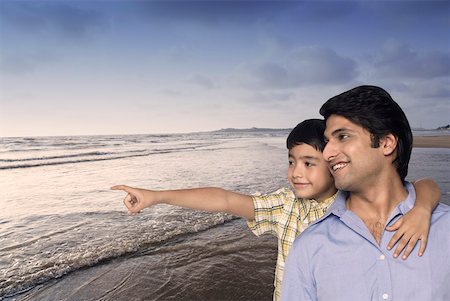 simsearch:630-02219554,k - Close-up of a young man and his son smiling at the beach Stock Photo - Premium Royalty-Free, Code: 630-02220342