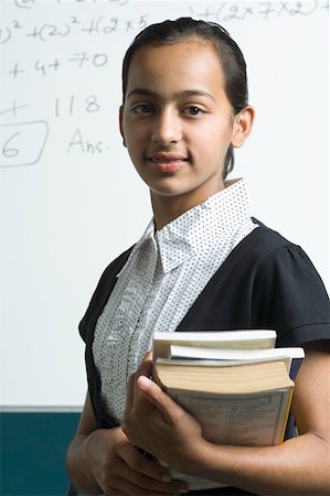 smart asian math - Portrait of a girl standing in front of a blackboard and holding books Stock Photo - Premium Royalty-Free, Code: 630-02220445