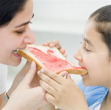 Close-up of a mid adult woman eating a bread Stock Photo - Premium Royalty-Free, Code: 630-02220524