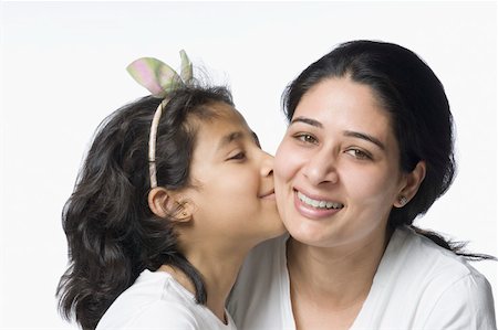 daughter kissing mother - Close-up of a girl kissing her mother and smiling Stock Photo - Premium Royalty-Free, Code: 630-02220526