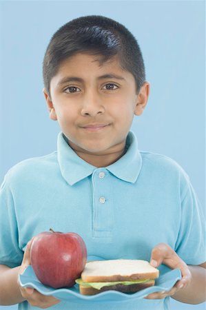 simsearch:630-02220721,k - Portrait of a boy holding a plate of an apple with a sandwich Foto de stock - Sin royalties Premium, Código: 630-02220599