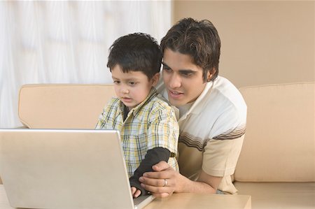 simsearch:630-02219554,k - Close-up of a young man using a laptop with his son and smiling Stock Photo - Premium Royalty-Free, Code: 630-02220608