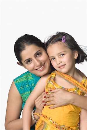 Portrait of a young woman hugging her daughter from behind and smiling Stock Photo - Premium Royalty-Free, Code: 630-02220685