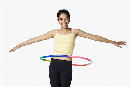 simsearch:630-02220846,k - Young woman spinning a plastic hoop around her waist Stock Photo - Premium Royalty-Free, Code: 630-02220852