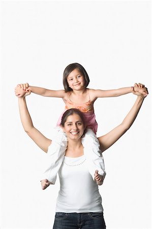 dancing indian girls images - Portrait of a young woman carrying her daughter on her shoulders and smiling Stock Photo - Premium Royalty-Free, Code: 630-02220887